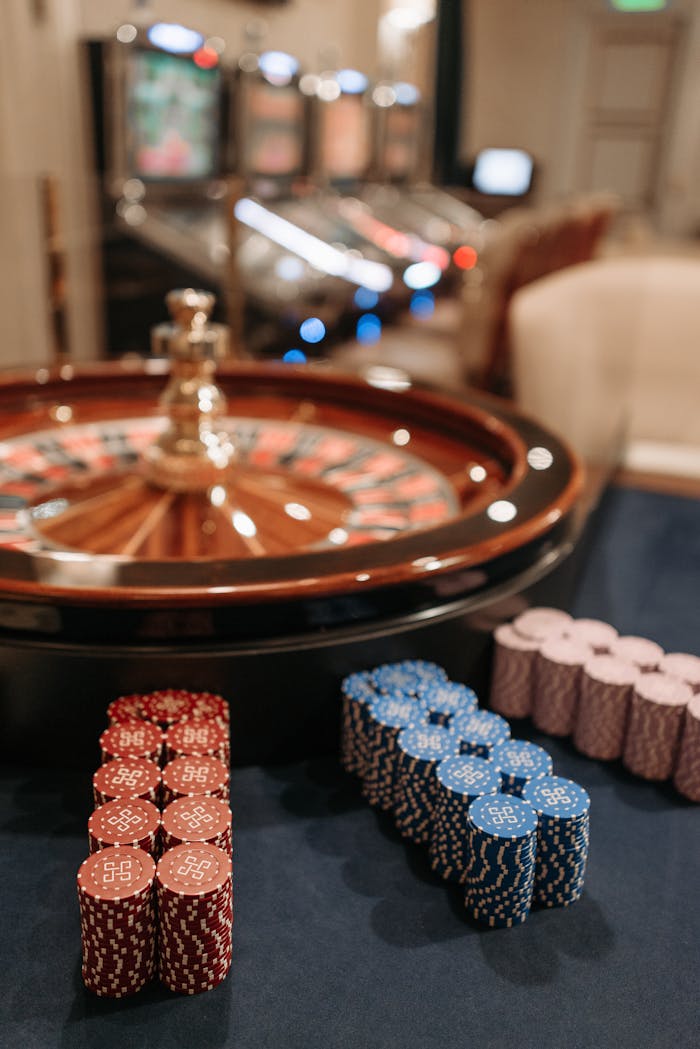 Roulette table with red, blue, and purple casino chips in focus inside a casino.