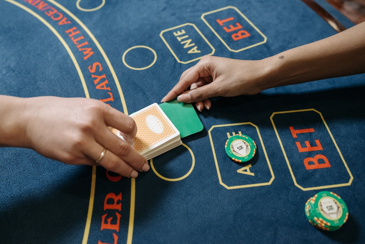 Intimate view of poker game in a casino with two hands exchanging cards on the table.